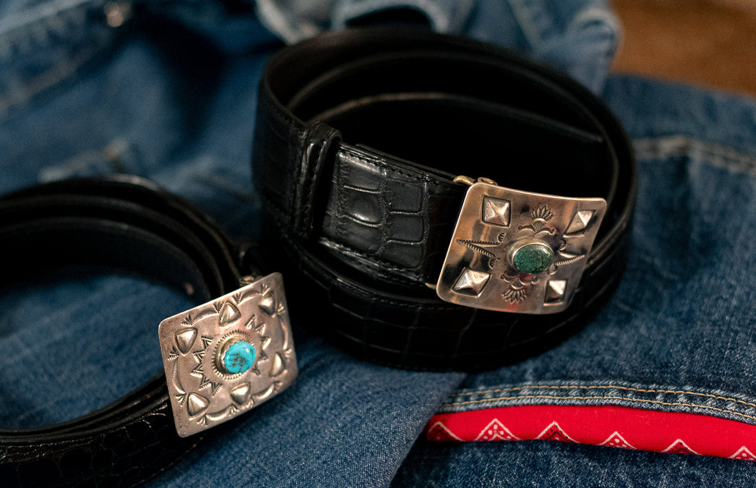 Red rabbit Trading Co. And Bryceland’s & Co. Collaboration silver and turquoise belt buckle inspired by Oppenheimer film staring cillian Murphy. Resting on denim jeans. Alligator skin black belt. 